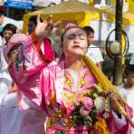 Female psychic medium follower of the Bang New Shrine with a long and thick needle pierced through her cheek, taking part in a street procession during the Chinese annual vegetarian festival. Phuket, Kingdom of Thailand, Indochina, South East Asia