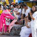 Female psychic medium follower of the Bang New Shrine, giving spiritual blessing to a sick woman in a wheel chair, during the street procession in the annual Chinese vegetarian festival. Phuket, Kingdom of Thailand, Indochina, South East Asia