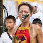 Psychic medium follower of the Bang New Shrine, with a long and thick needle pierced through his tongue, taking part in a street procession during the annual Chinese vegetarian festival. Phuket, Kingdom of Thailand, Indochina, South East Asia