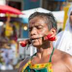 Psychic medium follower of the Bang New Shrine, with two long and thick needles pierced through his cheecks, taking part in a street procession during the annual Chinese vegetarian festival. Phuket, Kingdom of Thailand, Indochina, South East Asia