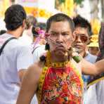 Psychic medium follower of the Bang New Shrine, with two long and thick needles pierced through his cheecks, taking part in a street procession during the annual Chinese vegetarian festival. Phuket, Kingdom of Thailand, Indochina, South East Asia