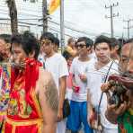 Psychic mediums followers of the Bang New Shrine, with a bunch of long and thic needles pierced through their cheecks, taking part in a street procession during the annual Chinese vegetarian festival. Phuket, Kingdom of Thailand, Indochina, South East Asia