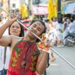 Psychic medium follower of the Bang New Shrine, with a long and thick rod pierced through his cheeck, taking part in a street procession during the annual Chinese vegetarian festival. Phuket, Kingdom of Thailand, Indochina, South East Asia