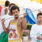 Psychic medium follower of the Bang New Shrine, with a very long and thick rod pierced through his cheeck, taking part in a street procession during the annual Chinese vegetarian festival. Phuket, Kingdom of Thailand, Indochina, South East Asia