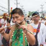 Psychic medium follower of the Bang New Shrine, with thick and thick rods pierced through his cheecks, taking part in a street procession during the annual Chinese vegetarian festival. Phuket, Kingdom of Thailand, Indochina, South East Asia