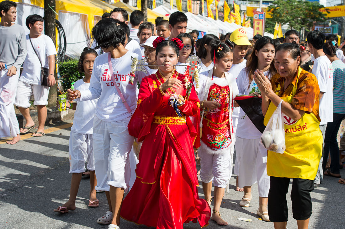 Female psychic medium follower of the Bang New Shrine with a rod pierced through her cheek, taking part in a street procession during the Chinese annual vegetarian festival. Phuket, Kingdom of Thailand, Indochina, South East Asia