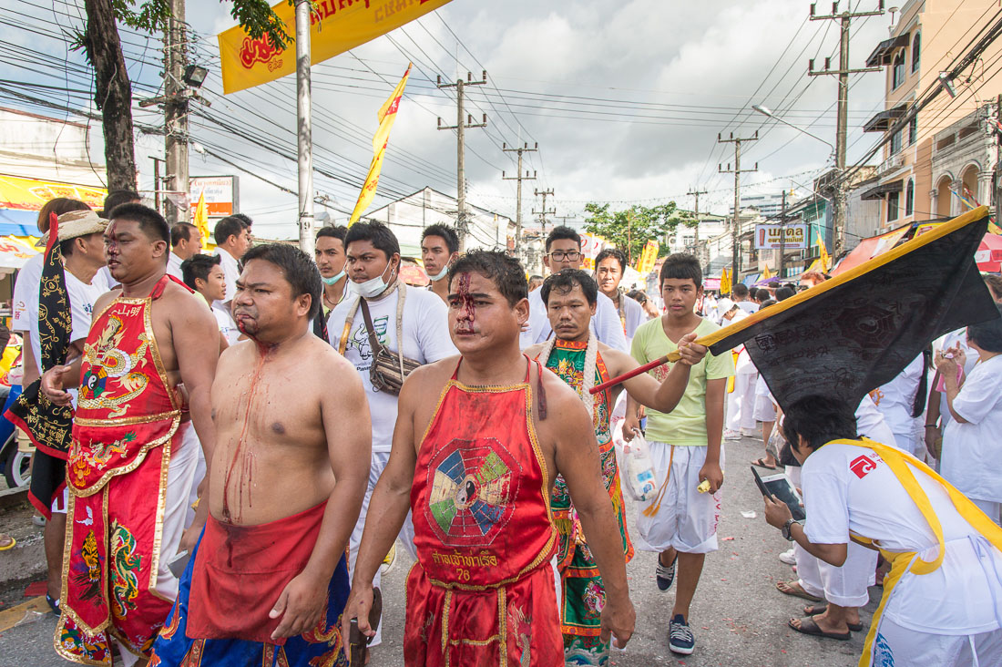 Psychic mediums followers of the Bang New Shrine, with chests covered by blood from self inflicted injuries on their faces, taking part in a street procession during the annual Chinese vegetarian festival. Phuket, Kingdom of Thailand, Indochina, South East Asia
