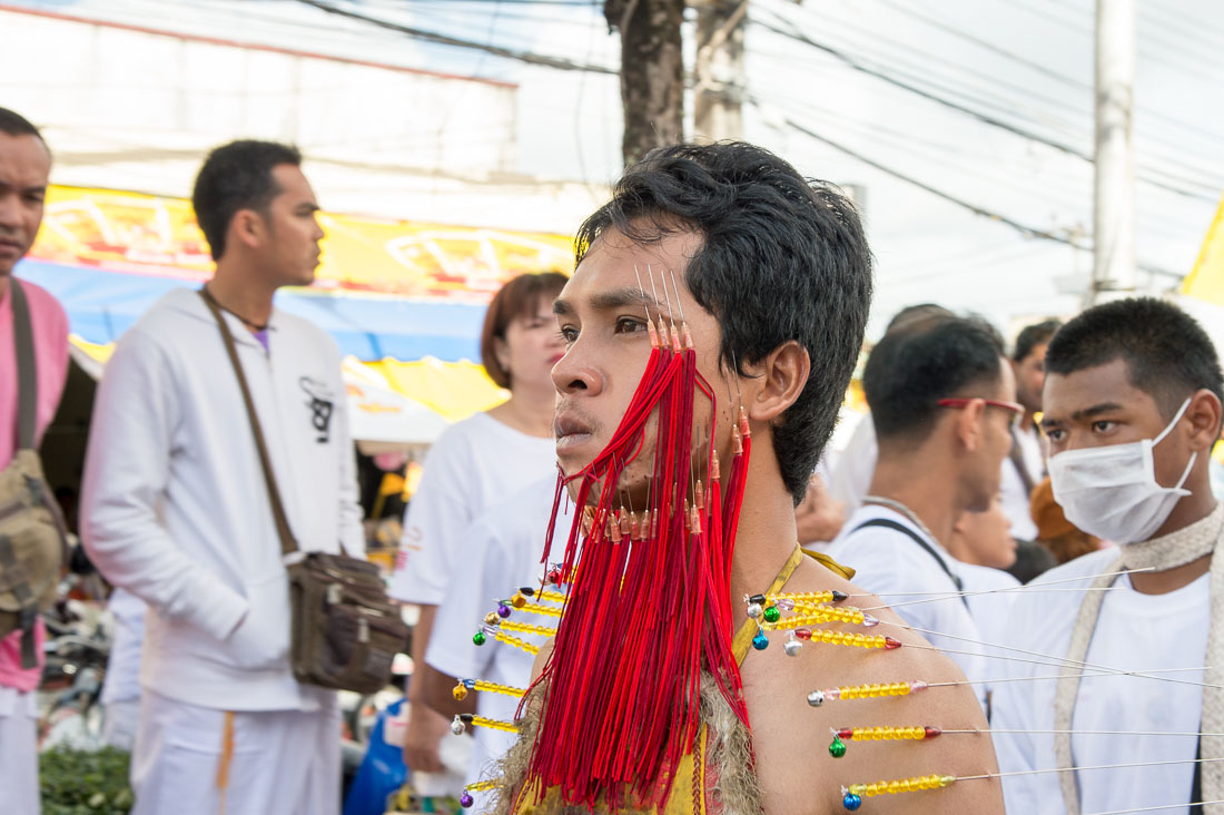 Psychic medium follower of the Bang New Shrine, with a bunch of needles pierced through his face and body, taking part in a street procession during the annual Chinese vegetarian festival. Phuket, Kingdom of Thailand, Indochina, South East Asia
