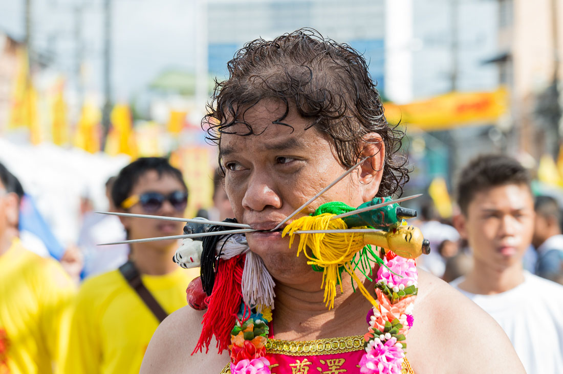 Psychic medium follower of the Bang New Shrine, with two long and thick needles pierced through his cheecks, taking part in a street procession during the annual Chinese vegetarian festival. Phuket, Kingdom of Thailand, Indochina, South East Asia