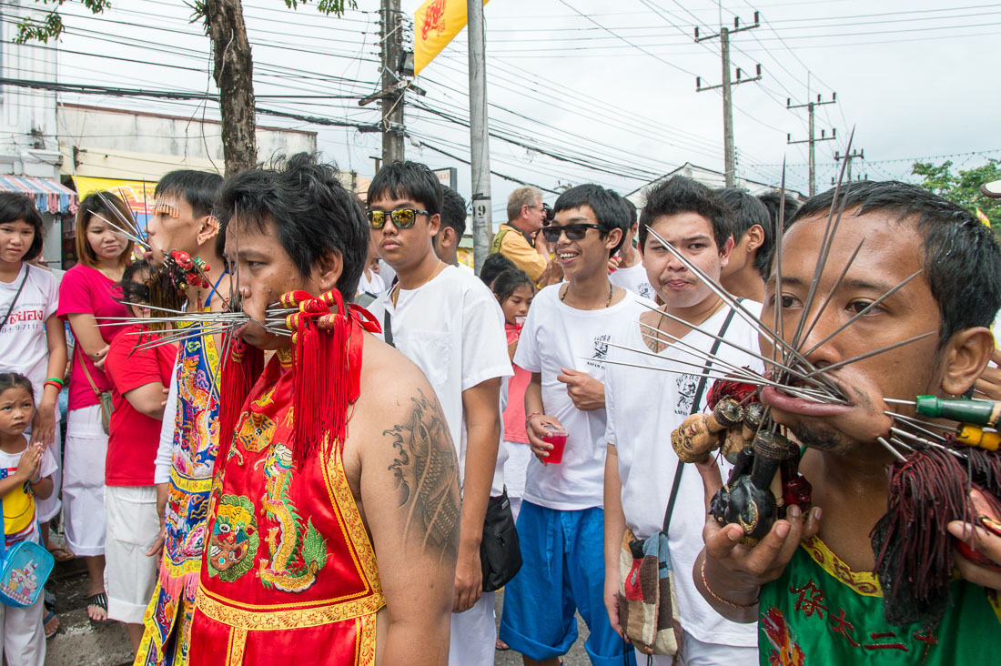 Psychic mediums followers of the Bang New Shrine, with a bunch of long and thic needles pierced through their cheecks, taking part in a street procession during the annual Chinese vegetarian festival. Phuket, Kingdom of Thailand, Indochina, South East Asia