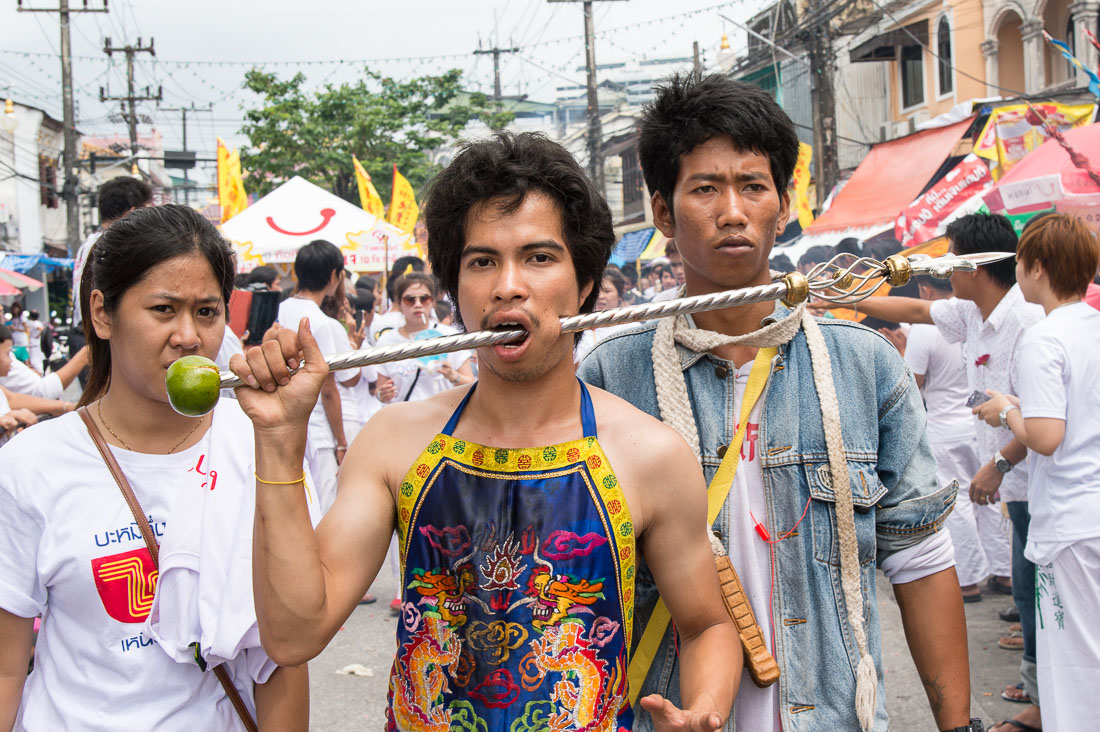 Psychic medium follower of the Bang New Shrine, with thick rod pierced through his cheeck, taking part in a street procession during the annual Chinese vegetarian festival. Phuket, Kingdom of Thailand, Indochina, South East Asia