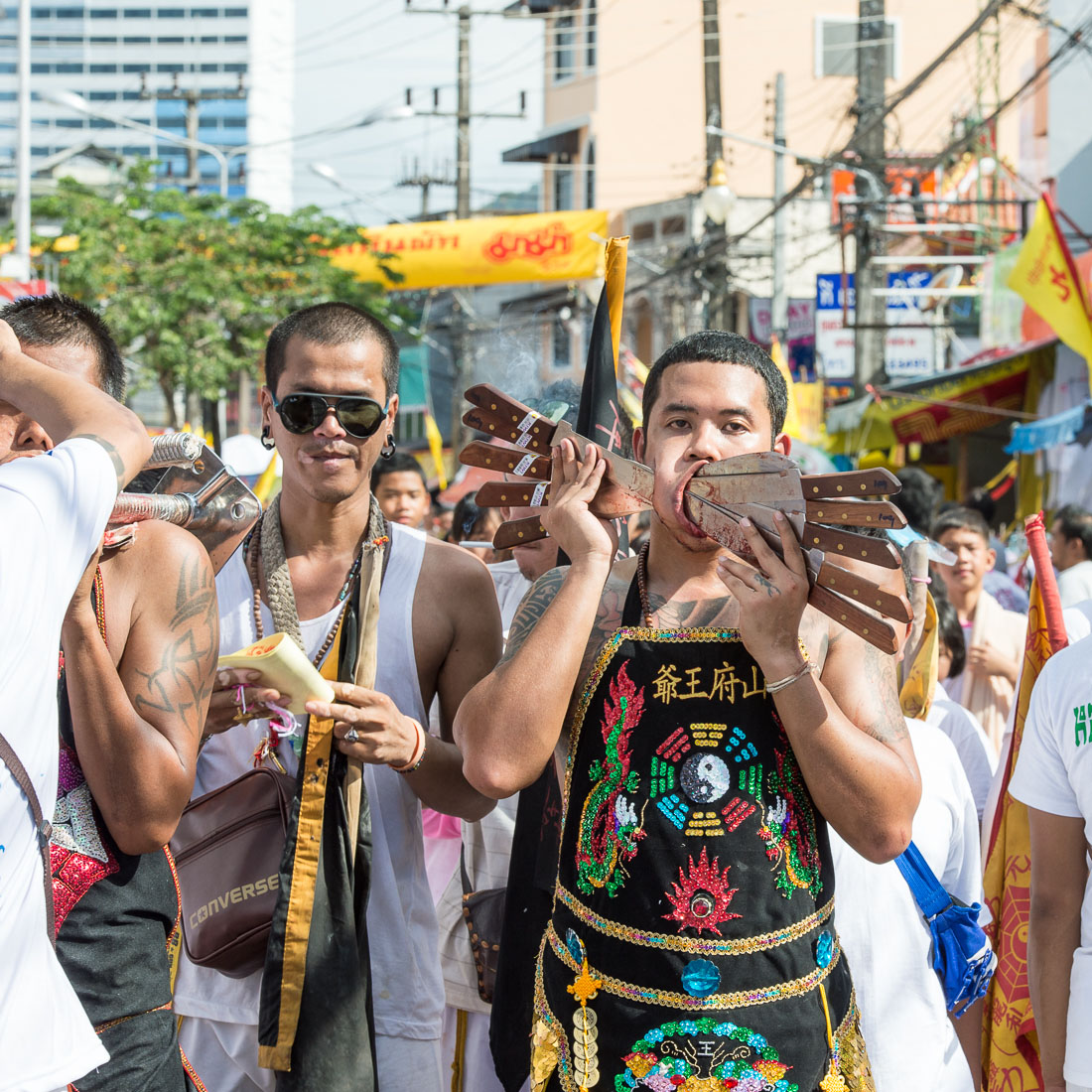 Psychic medium follower of the Bang New Shrine, with ten long knives blades pierced through his cheecks, taking part in a street procession during the annual Chinese vegetarian festival. Phuket, Kingdom of Thailand, Indochina, South East Asia