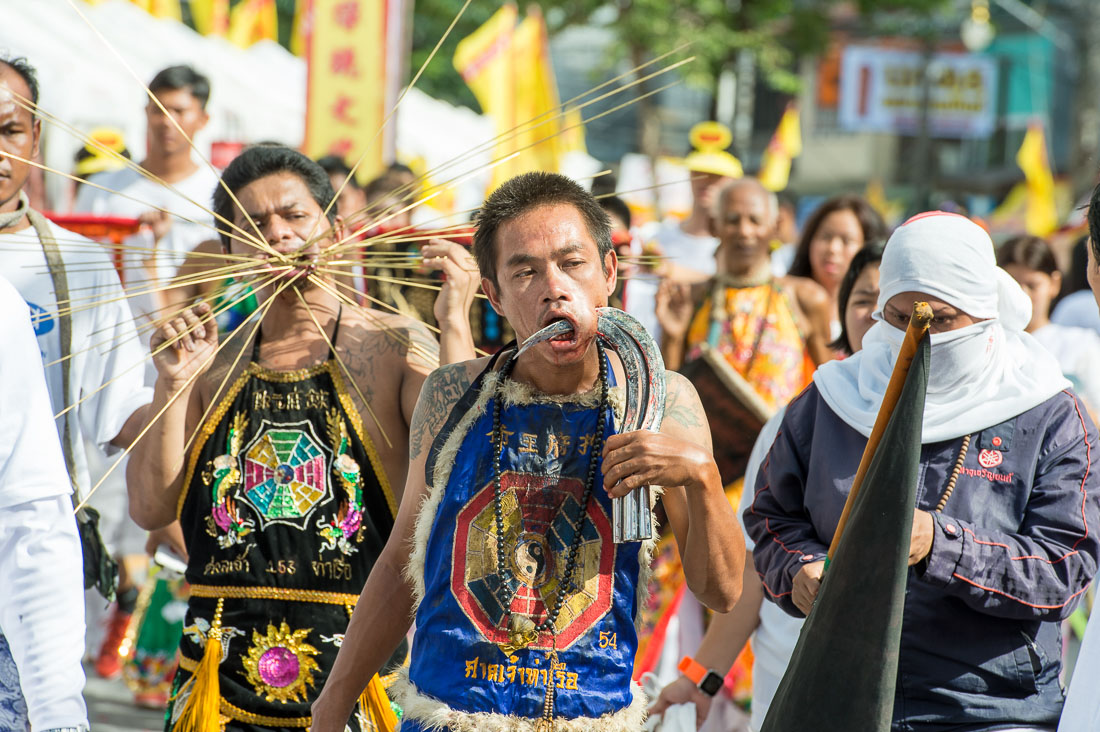 Psychic medium follower of the Bang New Shrine, with four sickles pierced through his cheeck, taking part in a street procession during the annual Chinese vegetarian festival. Phuket, Kingdom of Thailand, Indochina, South East Asia