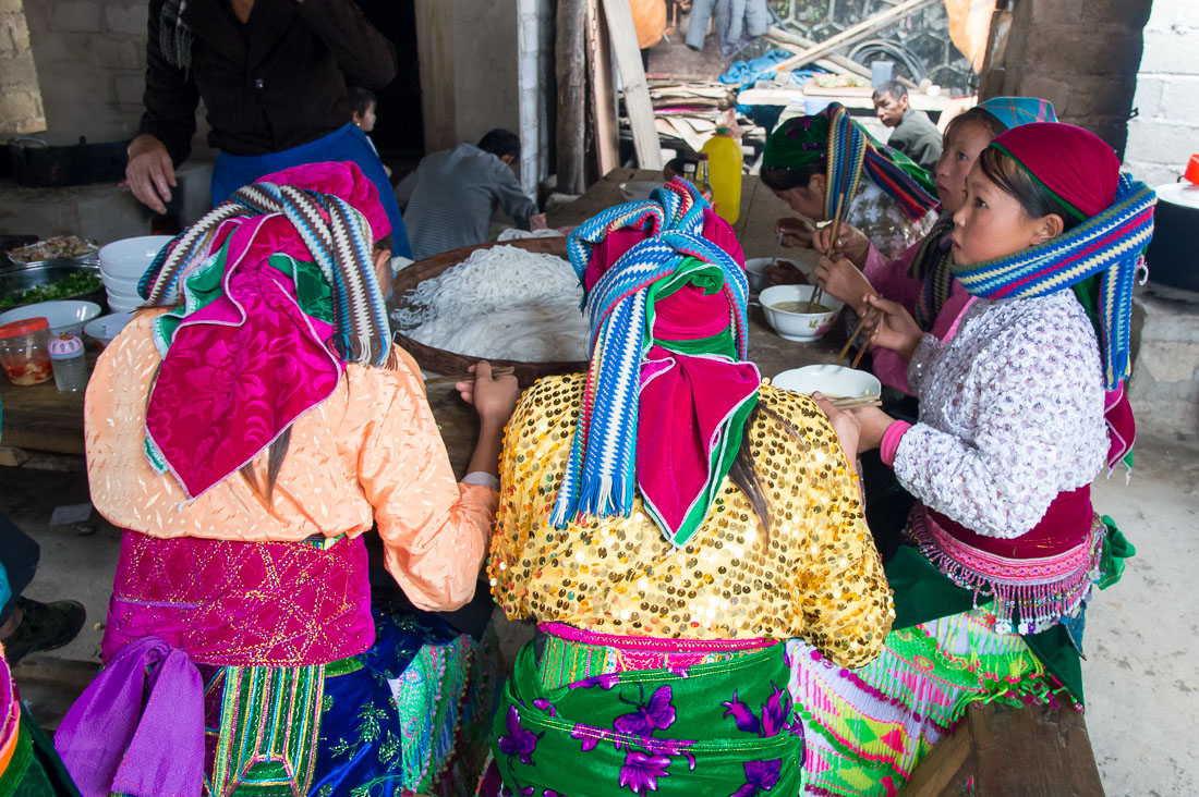 Women from the Balck Hmong people ethnic minority group havng lunch at busy market in Dong Van, Ha Giang Province, Viet Nam, Indochina, South East Asia