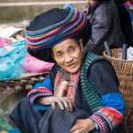 Woman from the Dao people ethnic minority group, wearing turban hat and traditional clothes with her bamboo smoking bong. Lung Phin market, Ha Gang province, Viet Nam, Indonesia, South East Asia