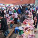 Butchers from the Black Hmong people ethnic minority group selling pig meat at the busy market in Dong Van, Ha Giang Province, Viet Nam, Indochina, South East Asia.