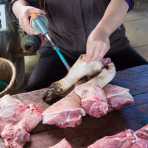 Burning hair from pig legs with a propane torch, Bac Ha market, Lao Cai province. Viet Nam, Indochina, South East Asia.