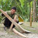 A man, from the Black Hmong ethnic minority, trying to put together a plow for the incoming rice season. Viet Nam, Indochina, South East Asia.