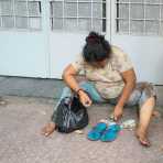 A female beggar counting her cash. Ho Chi Minh City (Saigon), Viet Nam, Indochina, South East Asia.