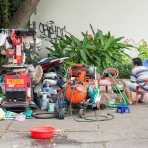 A tire repair shop operating on the walkside, fully equipped with industrial air compressor and hand free tire changer, Ho Chi Minh City (Saigon). Viet Nam, Indochina, South East Asia.