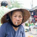 Old Vietnamese woman, smoking a cigarette at Hoi An market, Quang Nam province, Viet Nam, Indochina, South East Asia.