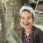 An old woman from the mountains in the Quang Nam Province, with her black stained teeth because of the addiction of chewing paan (lime, tobacco, areca nuts and betel leaves). Viet Nam, Indochina, South East Asia